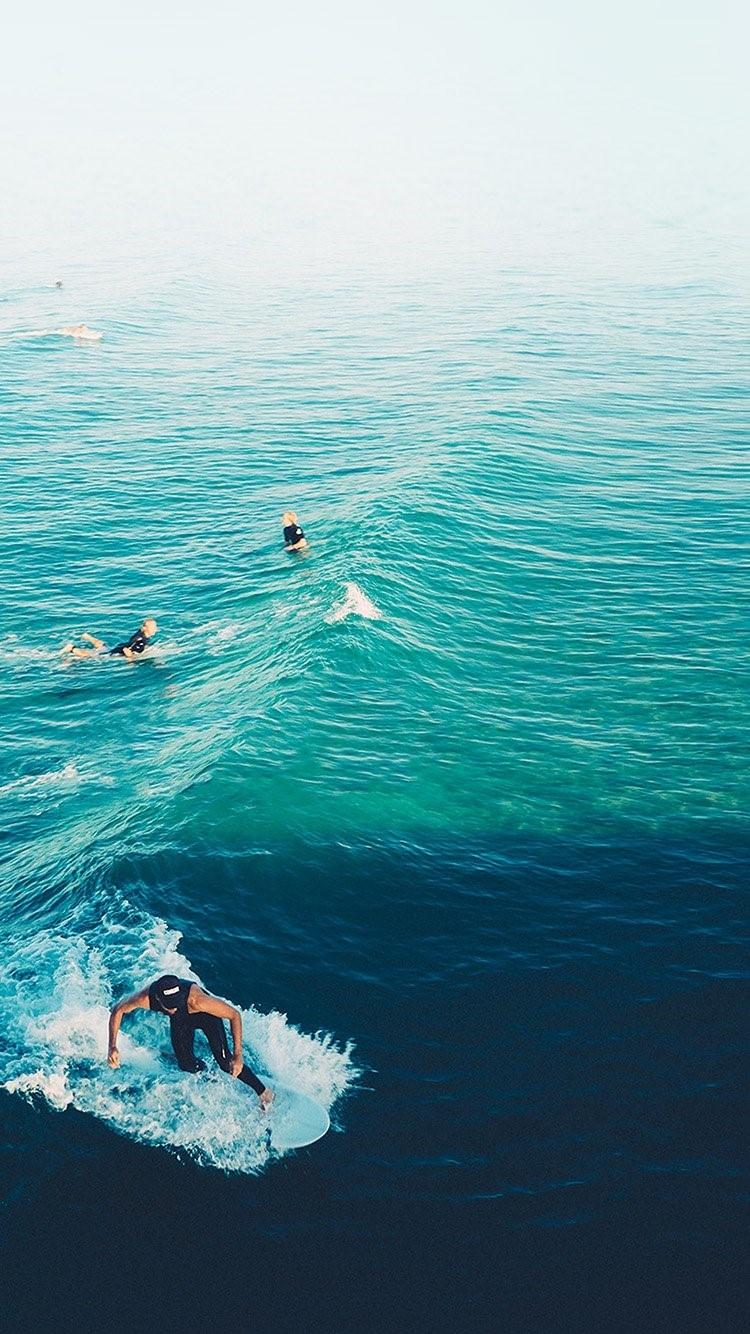 冲浪者在平静的海浪上练习iPhone 6壁纸